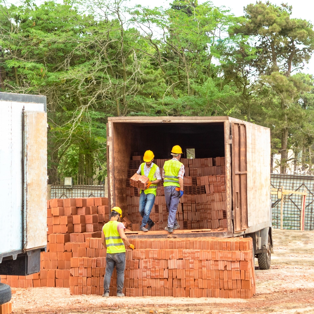 homens carregando tijolo